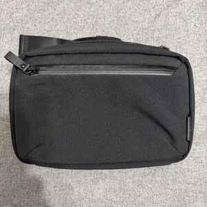 Alpaka black sling bag with front pocket and fidlock buckle